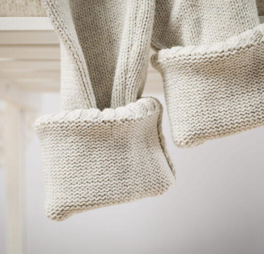 Sweater on white wooden chair, close up and selective focus